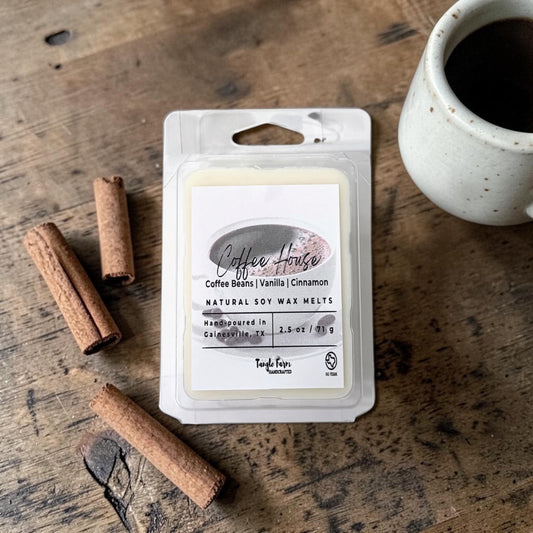 Pack of natural soy wax melts labeled 'Coffee House' with cinnamon sticks and a mug on a wooden surface.